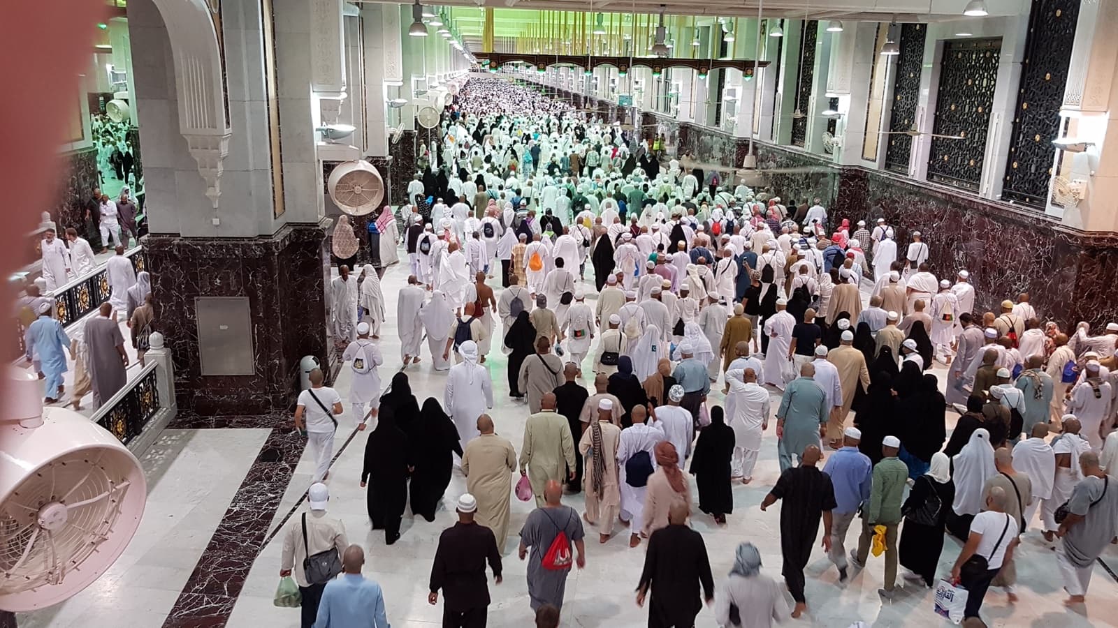 Pilgrims walking through a corridor at the Grand Mosque