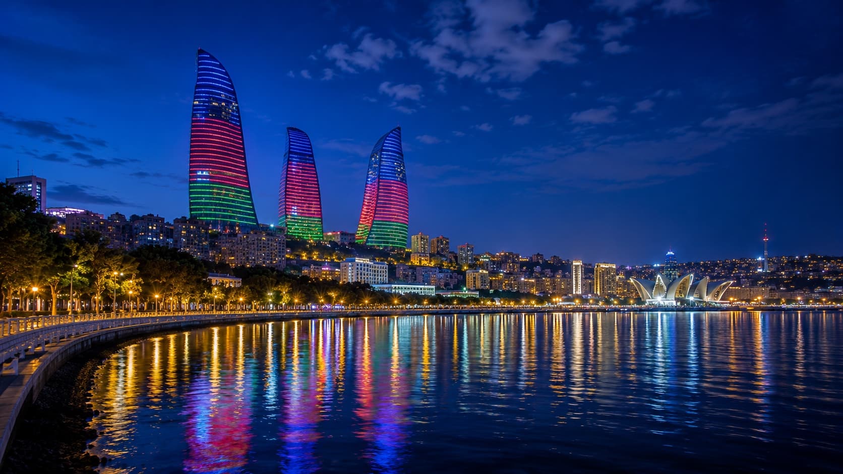 Baku Flame Towers illuminated at night with waterfront reflection